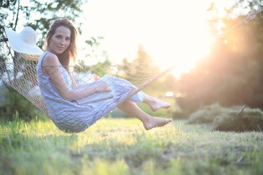 Yazın açık havada yalan söyleyen ve kitap okuyan güzel bir genç kız.