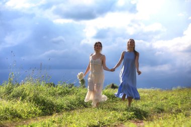 Genç kızlar tarlada Rai 'den önce yürüyor.