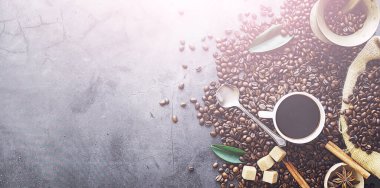 Bir poşet kahve. Kahve çekirdekleri masada kavrulmuş. Pişirmek için yapraklı kahve çekirdekleri.