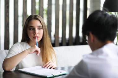 Ofis masasında konuşan bir çift genç.