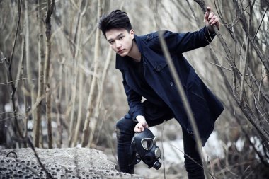 Paltolu ve gaz maskeli adam. Radyasyondan maskelenmiş Asyalı kıyamet sonrası portresi. Çocuk gazla zehirlendiği için maske takmış Koreli. Asya 'da nükleer maske