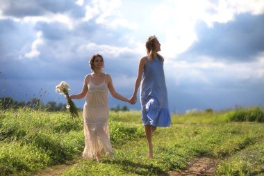 Genç kızlar tarlada Rai 'den önce yürüyor.