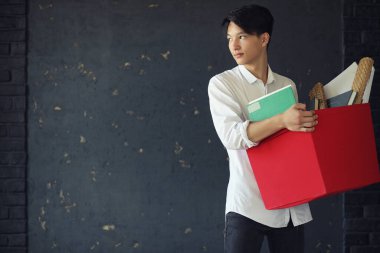 Elinde kitaplarla Asyalı genç bir öğrenci.