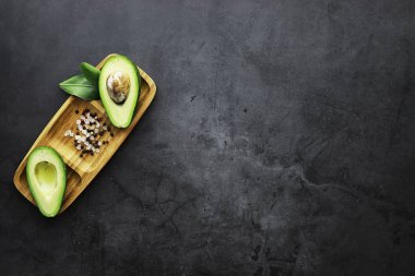 Avokado yemek tarifleri. Tahta kesme tahtasında servis edilen olgun yeşil avokado..