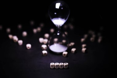 Kum saati ampulleri arasında koşan ve bir geri sayım bitiş tarihine kadar geçen zamanı ölçen, fotokopi alanı olan karanlık bir zemin arka planında..