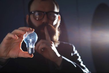 Takım elbiseli sakallı bir adam elinde bir nesne tutuyor. Zaman ve fikir kavramı. Özlem geliştirme.