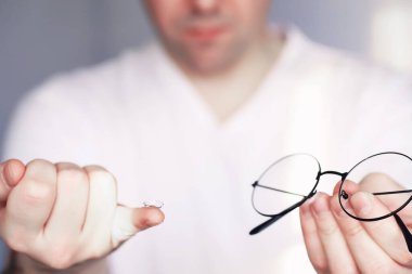 Kötü görüş kavramı. Kontak lens ve gözlüğü elinizde tutun. Reklam gözlükleri ve lensler için poster.