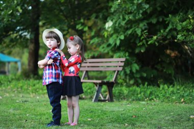 Sonbahar parkında yürüyüşe çıkmış çocuklar. Yaprak parkta düşer. - Aile. Düş! Mutluluk.