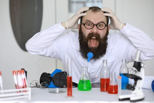 Chemist crazy. A mad scientist conducts experiments in scientific laboratory. Performs research using a microscope.