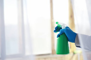 Ev temizliği konsepti. Yüzeylerin tozunu sil. Dezenfektan kapısı TV elektriğini kontrol ediyor. Evdeki karantinada hijyenik tedavi.