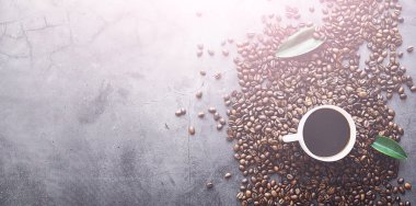 Bir poşet kahve. Kahve çekirdekleri masada kavrulmuş. Pişirmek için yapraklı kahve çekirdekleri.