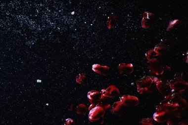 Olgun tatlı nar tohumlarına su damlaları düşer. Metnin için kopyalama alanı olan taze nar arkaplanı. Vejetaryen ve vejetaryen kavramı.