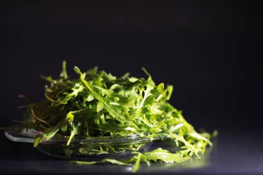 Taze roka kevgirle yapılır. Siyah arka plan. Yeşil yapraklı ve sebzeli yeşil vejetaryen salatası.