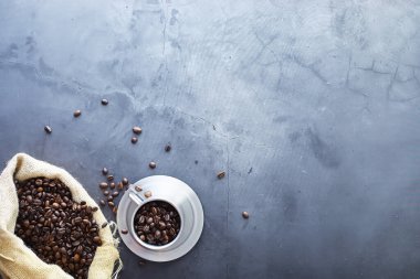 Bir poşet kahve. Kahve çekirdekleri masada kavrulmuş. Pişirmek için yapraklı kahve çekirdekleri.