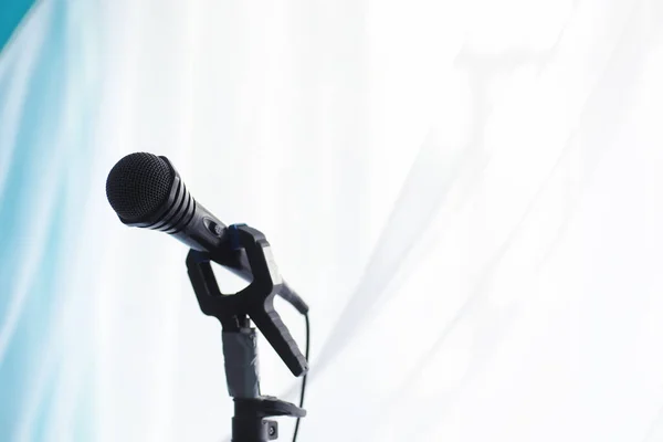 Stand with a microphone. Man holds hands a microphone on tripod. Performance of the artist with a microphone. Scene with a microphone.