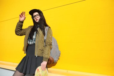 Genç hippi kız bir kaykay sürme. Kızlar kız şehirde bir kaykay ile yürüyüşe. Bahar spor bir kaykay ile sokakta