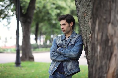 Genç bir adam öğle yemeği zamanında parkta yürür. Bir adam şehirde gezintiye çıktı. Park eden bir öğrenci.