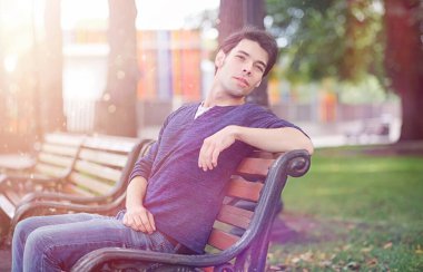 Genç bir adam öğle yemeği zamanında parkta yürür. Bir adam şehirde gezintiye çıktı. Park eden bir öğrenci.