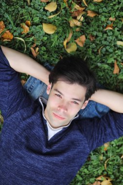 Genç bir adam öğle yemeği zamanında parkta yürür. Bir adam şehirde gezintiye çıktı. Park eden bir öğrenci.