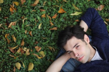 Genç bir adam öğle yemeği zamanında parkta yürür. Bir adam şehirde gezintiye çıktı. Park eden bir öğrenci.