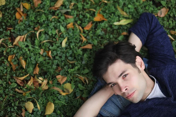 Genç bir adam öğle yemeği zamanında parkta yürür. Bir adam şehirde gezintiye çıktı. Park eden bir öğrenci.