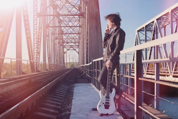 Bir elektro gitar demiryolu üzerinde olan bir adam. Organize sanayi bölgesinde sokakta bir gitar ile deri ceketli bir müzisyen. Köprüde gitarist