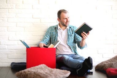 Odada genç bir öğrenci gazete okuyor.