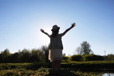 Güneşli bir günün akşamında parkta bir kız.