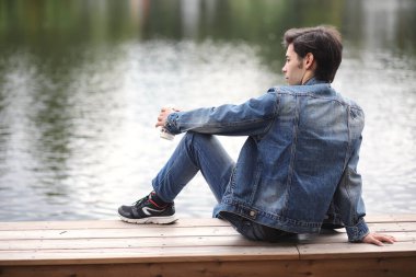 Genç bir adam öğle yemeği zamanında parkta yürür. Bir adam şehirde gezintiye çıktı. Park eden bir öğrenci.