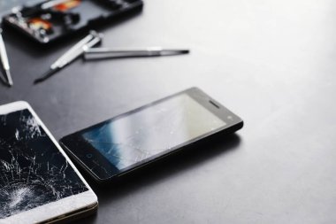 Kırık dokunmatik ekranlı akıllı telefon. Cep telefonu bozuk. Telefon bozuldu. Cep telefonuna kırık cam takmak. Akıllı telefon onarımı.