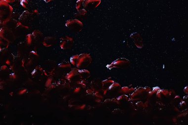 Olgun tatlı nar tohumlarına su damlaları düşer. Metnin için kopyalama alanı olan taze nar arkaplanı. Vejetaryen ve vejetaryen kavramı.