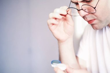 Kötü görüş kavramı. Kontak lens ve gözlüğü elinizde tutun. Reklam gözlükleri ve lensler için poster.