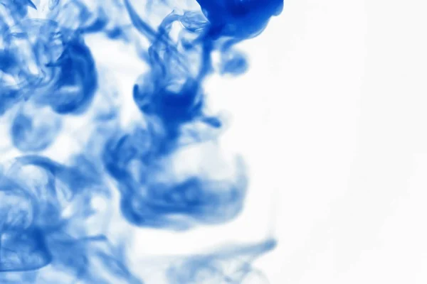 Puffs of paint in water. The dissolution of dye in water. Water pollution. Concept art creativity.