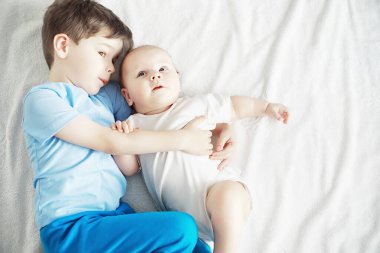 Çocuklar yeni doğan bebeğin yanında yatar, küçük kardeşim. Çocukların duyguları..