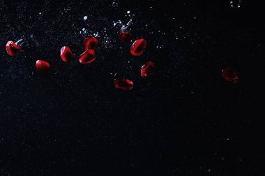 Olgun tatlı nar tohumlarına su damlaları düşer. Metnin için kopyalama alanı olan taze nar arkaplanı. Vejetaryen ve vejetaryen kavramı.