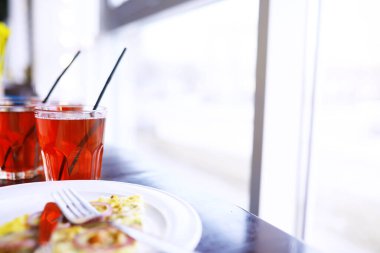 yakın plan pastırmalı pizza, portakal suyu bir restorandaki bir kafede masanın üstünde.