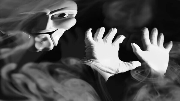 White scary mask on a black background with whites hands.