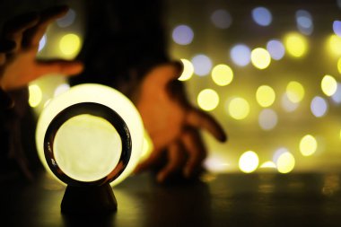 Yerde Bokeh 'le kristal küre var. Renkli ışık saçan cam top, yeni yıl kutlaması konsepti..