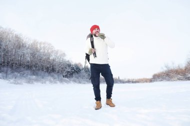 Bir adam sırt çantasıyla seyahat eder. Ormanda kış yürüyüşü. Kışın parkta yürüyüş yapan bir turist..