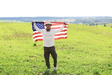 Tarla, bayram, vatanseverlik, gurur, özgürlük, siyasi partiler ve göçmen bayrağını sallayan adam