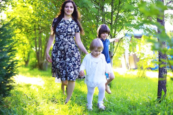 Young large family on a summer morning walk. Beautiful mother with children playing in the park.