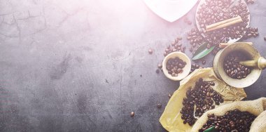 Bir poşet kahve. Kahve çekirdekleri masada kavrulmuş. Pişirmek için yapraklı kahve çekirdekleri.