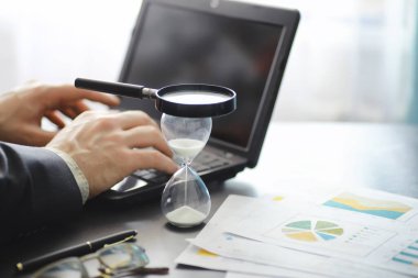 Çalışma zamanı kum saatini sembolize eder. Sigorta müdürü ve bankacı ile ofis masası. Ofis çalışanı masada. Zaman eksikliği kavramı.