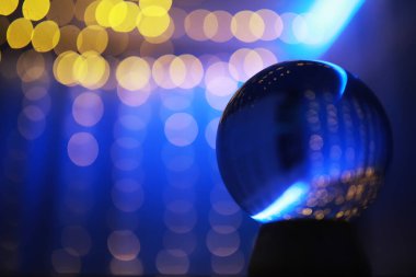 Yerde Bokeh 'le kristal küre var. Renkli ışık saçan cam top, yeni yıl kutlaması konsepti..