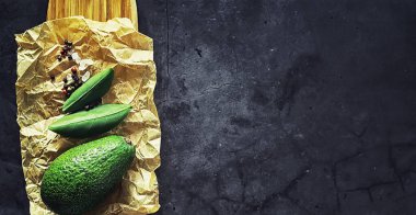 Avokado yemek tarifleri. Tahta kesme tahtasında servis edilen olgun yeşil avokado..