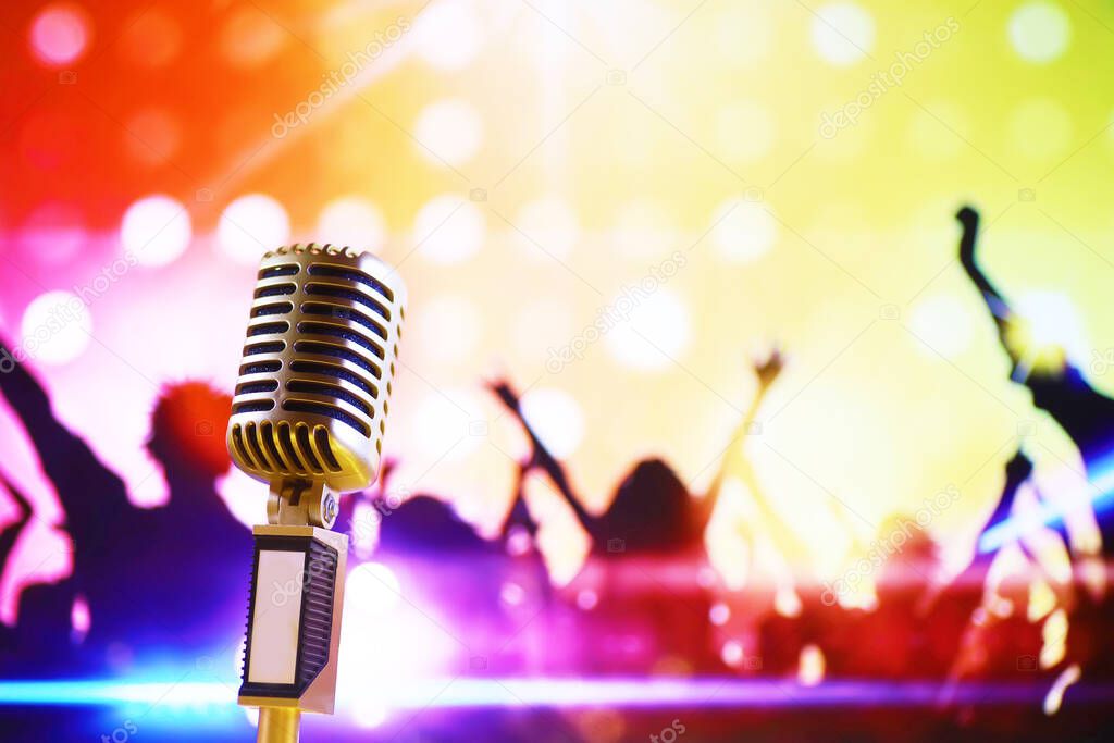 Retro style microphone on background with backlight. Vintage silver Microphone for sound, music, karaoke. Speech broadcast equipment. Live pop, rock musical performance. Selective focu