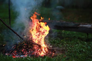 Büyük ateşte yanan kızıl kıvılcımlar uçuşur. Yanan kömürler, yanan parçacıklar siyah arkaplanda uçuşuyor..