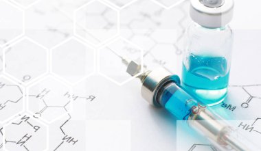 Kimyasal formülün yanındaki mavi arka planda enjeksiyon için küçük kavanozlar ve şırıngalar.