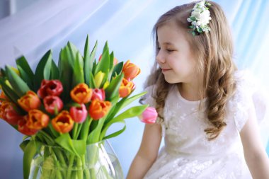 Beyaz elbiseli, muhteşem bir buket lalesi olan güzel bir kız. Uluslararası Kadınlar Günü. Laleli kız.