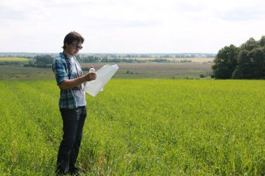Genç bir adam kaybolmamak için doğadaki haritaya bakar.
